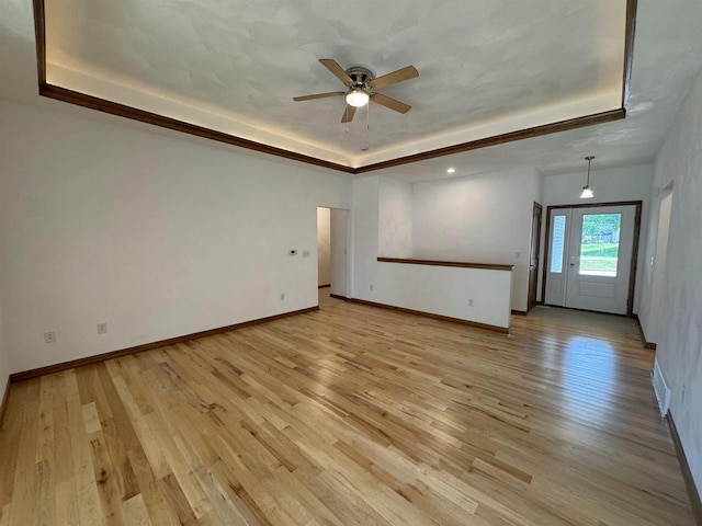 1511 16th Ave, Monroe, WI 53566 - spare room featuring a tray ceiling, light wood-style floors, ceiling fan, and baseboards