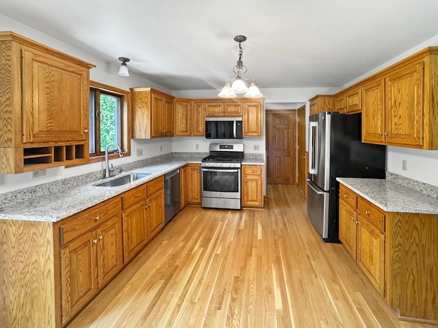 N49W31242 Old Steeple Rd, Hartland, WI 53029 - kitchen featuring stainless steel appliances, a sink, brown cabinets, and light wood-style flooring
