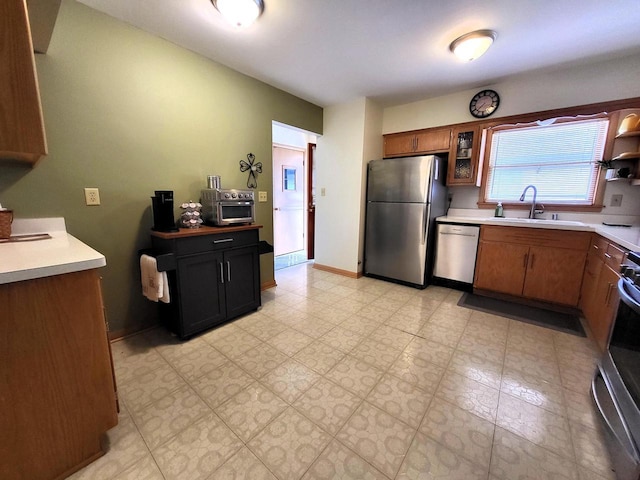 3843 S 95th St, Milwaukee, WI 53228 - kitchen with stainless steel appliances, a sink, light countertops, glass insert cabinets, and brown cabinetry