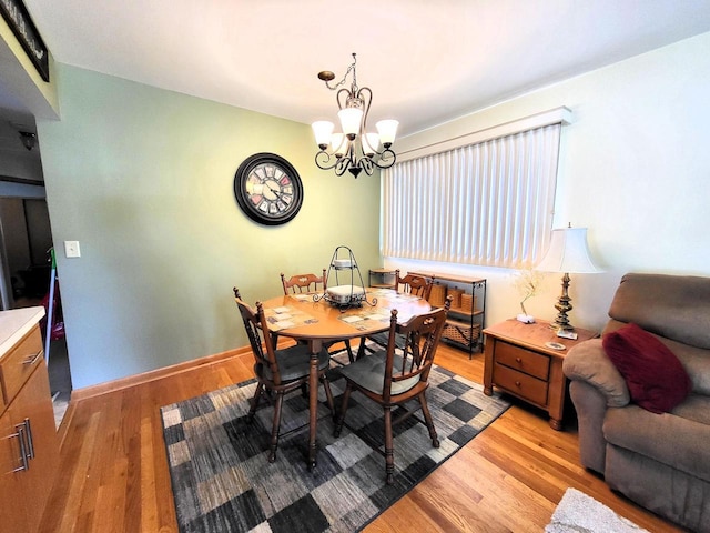 3843 S 95th St, Milwaukee, WI 53228 - dining area with light wood-style floors, a chandelier, and baseboards