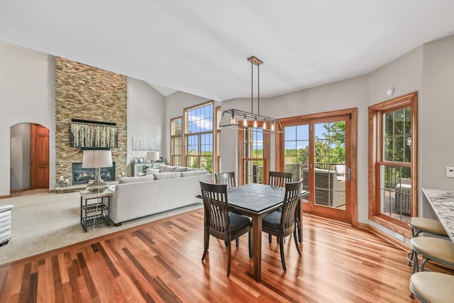 W226N3550 Wethersfield Rd, Pewaukee, WI 53072 - dining room with light wood-type flooring, plenty of natural light, a stone fireplace, and arched walkways