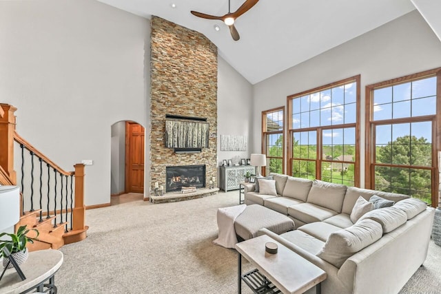 W226N3550 Wethersfield Rd, Pewaukee, WI 53072 - carpeted living room with high vaulted ceiling, ceiling fan, a stone fireplace, arched walkways, and stairway