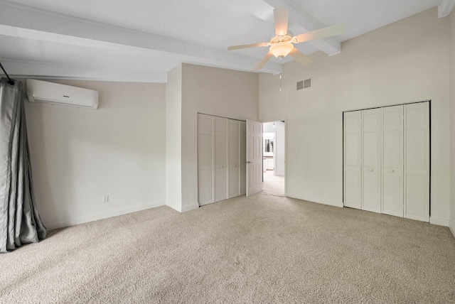 840 Woodland Ct Unit Ee-1, Fontana, WI 53125 - unfurnished bedroom featuring an AC wall unit, multiple closets, light colored carpet, a high ceiling, and baseboards