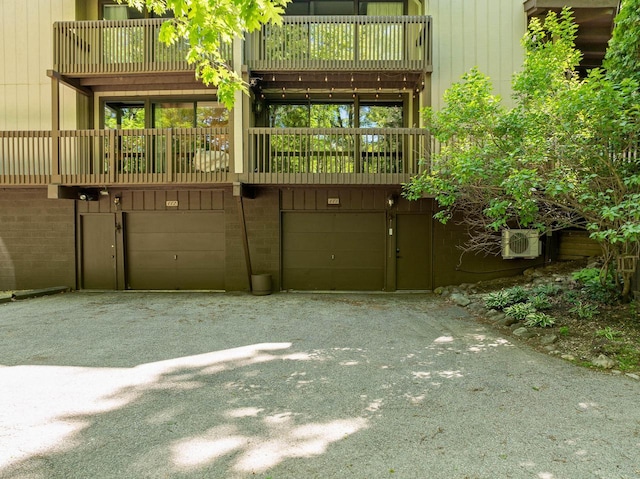 840 Woodland Ct Unit Ee-1, Fontana, WI 53125 - back of property featuring an attached garage, driveway, and ac unit