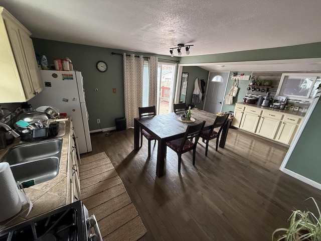 2143 Clark St, Mount Pleasant, WI 53403 - dining room featuring a textured ceiling, dark wood-type flooring, and baseboards
