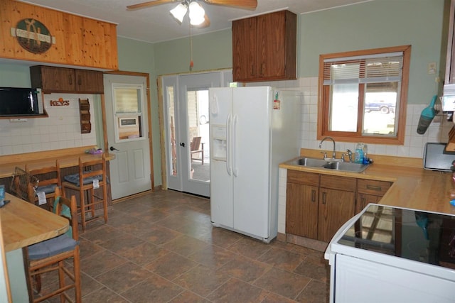 109 N Water St, Eastman, WI 54626 - kitchen with white appliances, a sink, ceiling fan, brown cabinetry, and tasteful backsplash