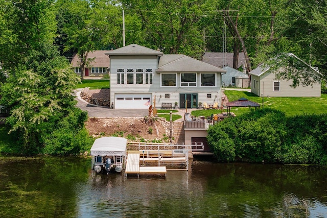5420 W Peninsula Dr, Waterford, WI 53185 - rear view of house featuring a water view, a garage, boat lift, and a lawn