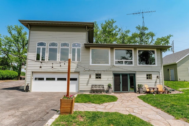 5420 W Peninsula Dr, Waterford, WI 53185 - rear view of property with an attached garage, asphalt driveway, and a lawn