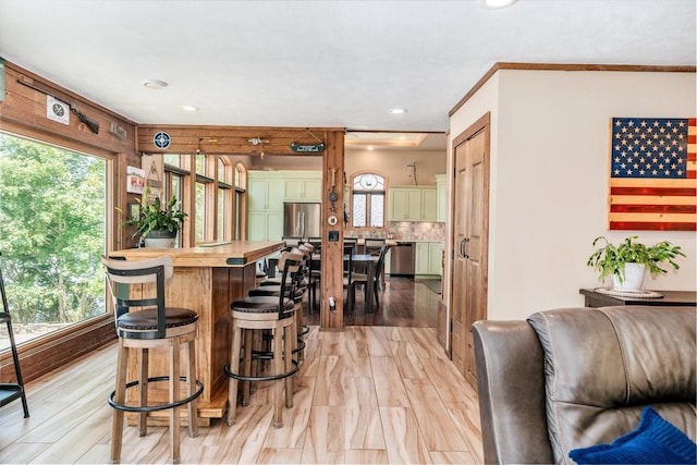 5420 W Peninsula Dr, Waterford, WI 53185 - kitchen featuring a kitchen breakfast bar, appliances with stainless steel finishes, light wood-type flooring, tasteful backsplash, and recessed lighting