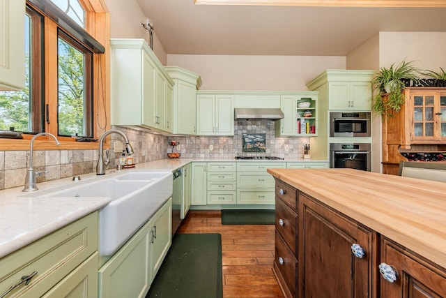 5420 W Peninsula Dr, Waterford, WI 53185 - kitchen featuring green cabinetry, stainless steel appliances, exhaust hood, and tasteful backsplash