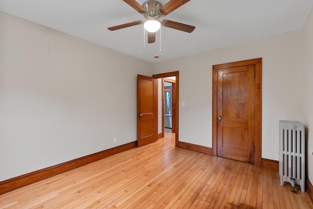 4438 County Road H Prt, Washington, WI 53074 - spare room featuring radiator heating unit, baseboards, light wood-style flooring, and ceiling fan
