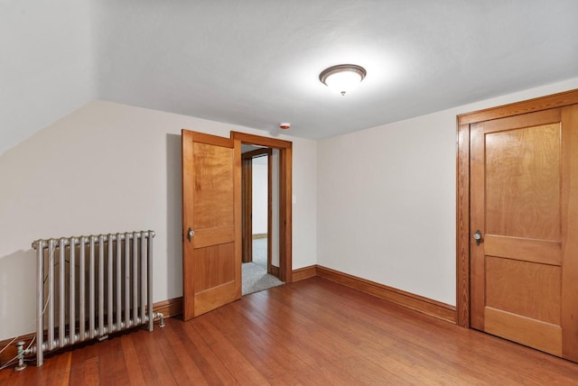 4438 County Road H Prt, Washington, WI 53074 - unfurnished room with radiator, wood-type flooring, baseboards, and lofted ceiling