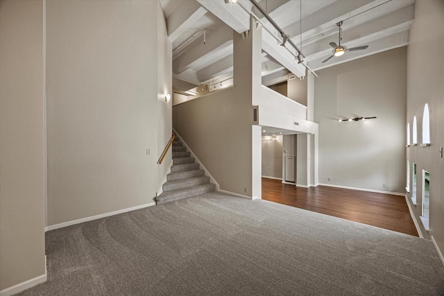 270 E Highland Ave Unit 213, Milwaukee, WI 53202 - unfurnished living room with carpet, a ceiling fan, baseboards, beam ceiling, and a towering ceiling