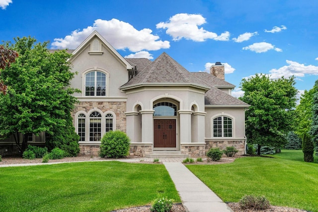 1252 Mary Hill Cir, Hartland, WI 53029 - french provincial home with stone siding, stucco siding, a front lawn, and roof with shingles