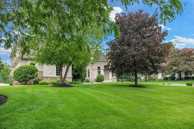 1252 Mary Hill Cir, Hartland, WI 53029 - view of property hidden behind natural elements with stone siding, a front yard, and stucco siding