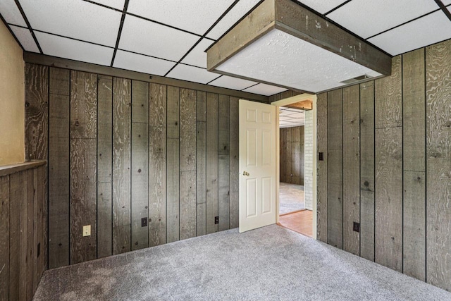 8845 388th Ave, Burlington, WI 53105 - unfurnished bedroom with wooden walls, carpet, and a paneled ceiling