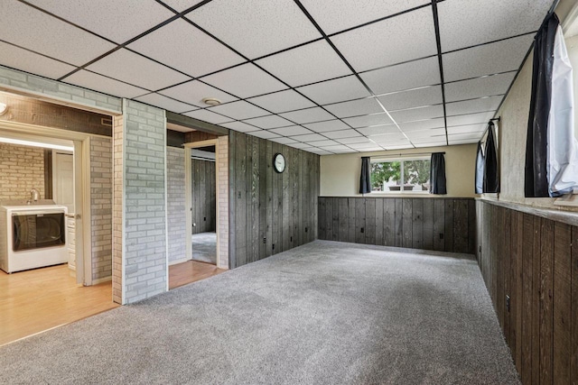 8845 388th Ave, Burlington, WI 53105 - empty room featuring washer / dryer, carpet, a drop ceiling, wooden walls, and wainscoting