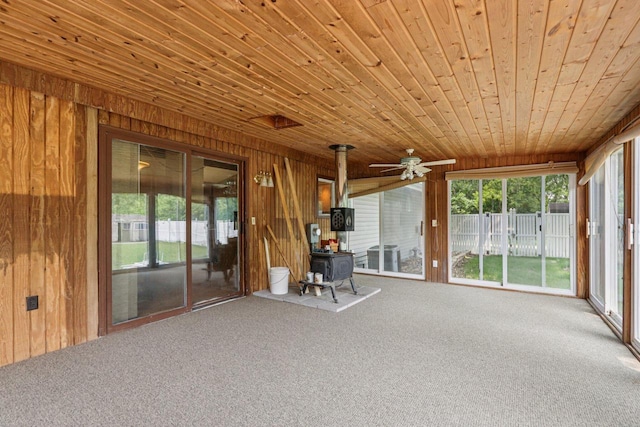 8845 388th Ave, Burlington, WI 53105 - unfurnished sunroom with a wood stove, carpet flooring, wood walls, and wood ceiling