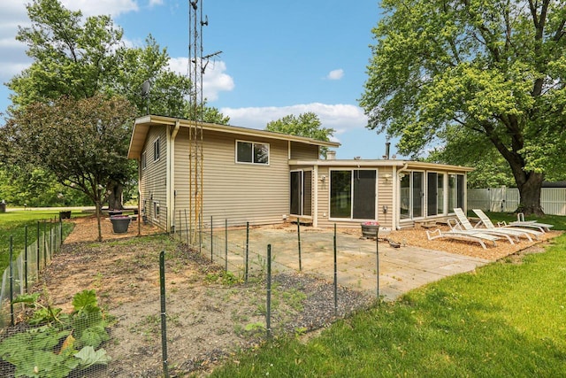 8845 388th Ave, Burlington, WI 53105 - rear view of house with a sunroom, a fenced backyard, and a patio area