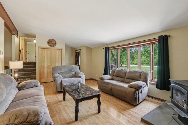 8845 388th Ave, Burlington, WI 53105 - living area featuring vaulted ceiling, light wood-type flooring, a wood stove, and stairs
