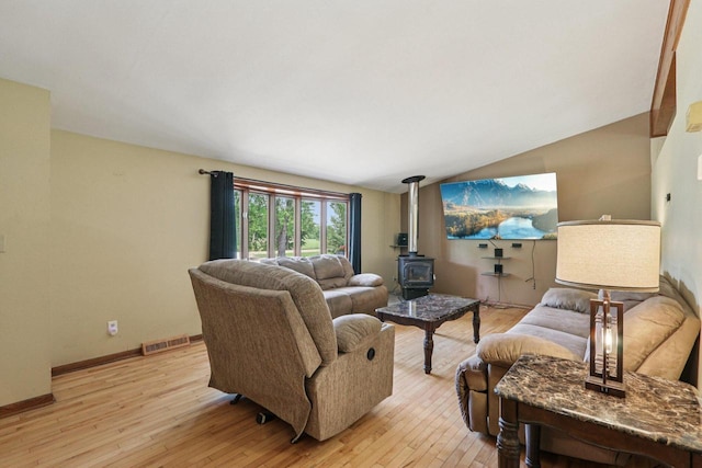 8845 388th Ave, Burlington, WI 53105 - living room featuring a wood stove, light wood-type flooring, and vaulted ceiling