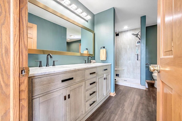 6705 Brian Dr, Waterford, WI 53185 - bathroom with double vanity, toilet, a stall shower, wood finished floors, and baseboards