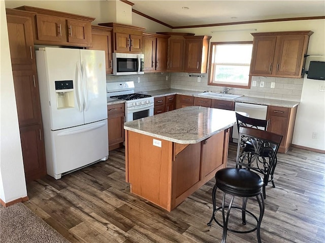 163 230th St, Osceola, WI 54020 - kitchen featuring white appliances, crown molding, a sink, dark wood-style floors, and a center island