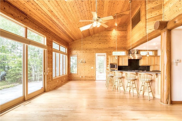11053 Robin Ln, Hayward, WI 54843 - kitchen with stainless steel microwave, wooden ceiling, a kitchen breakfast bar, a skylight, and wood walls