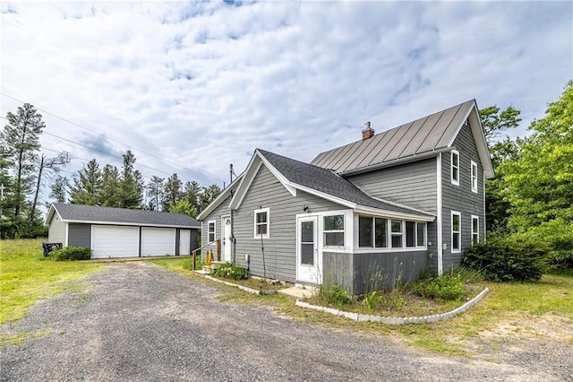 W9952 State Highway 54, Black River Falls, WI 54615 - view of side of home with an outdoor structure, a detached garage, a standing seam roof, a chimney, and metal roof