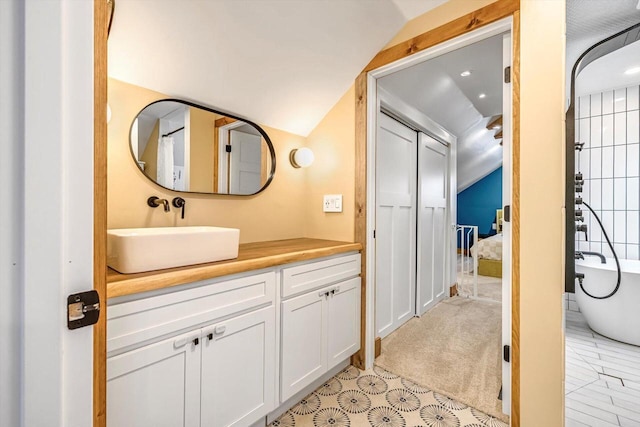 405 W Washington St, Waterford, WI 53185 - full bath with lofted ceiling, vanity, a freestanding tub, and tile patterned floors