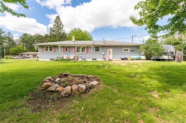 5603 170th St, Chippewa Falls, WI 54729 - rear view of property featuring a yard, an outdoor fire pit, and a chimney