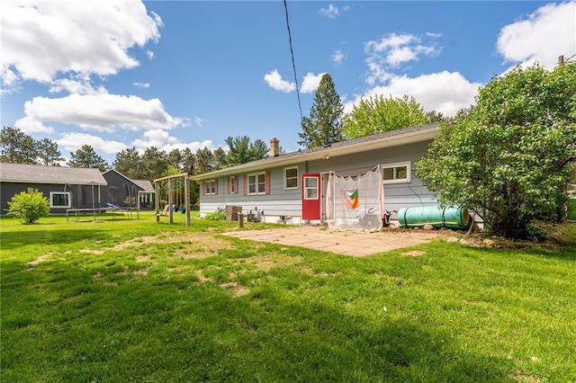 5603 170th St, Chippewa Falls, WI 54729 - rear view of property featuring a trampoline, a lawn, and a patio
