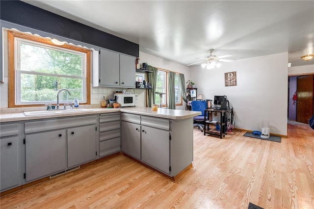 5603 170th St, Chippewa Falls, WI 54729 - kitchen with a sink, white microwave, a peninsula, and light wood finished floors