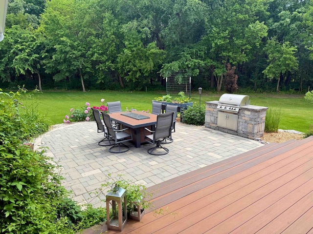 1102 Eldon Way, Edgerton, WI 53534 - wooden terrace featuring a patio, outdoor dining area, and a lawn