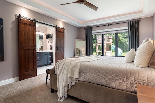 1102 Eldon Way, Edgerton, WI 53534 - bedroom featuring a barn door, light carpet, connected bathroom, a ceiling fan, and a tray ceiling