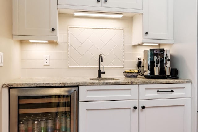 1102 Eldon Way, Edgerton, WI 53534 - kitchen featuring beverage cooler, tasteful backsplash, and white cabinetry