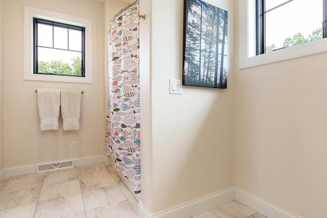 1102 Eldon Way, Edgerton, WI 53534 - full bathroom featuring plenty of natural light, marble look tiles, and a shower with shower curtain