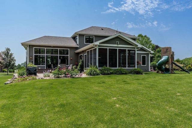 1102 Eldon Way, Edgerton, WI 53534 - rear view of house with a sunroom, a yard, a playground, and roof with shingles