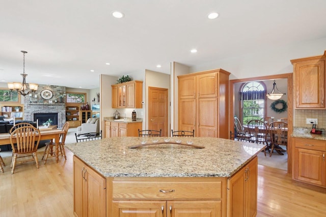 3944 Caribou Rd, Verona, WI 53593 - kitchen featuring a center island, light wood-style floors, open floor plan, light stone counters, and recessed lighting