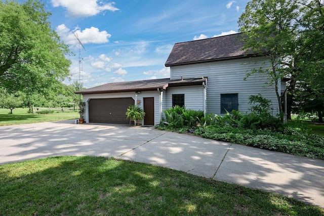 7129 S County Road Jj, Bancroft, WI 54921 - view of side of property featuring an attached garage, driveway, a shingled roof, and a lawn