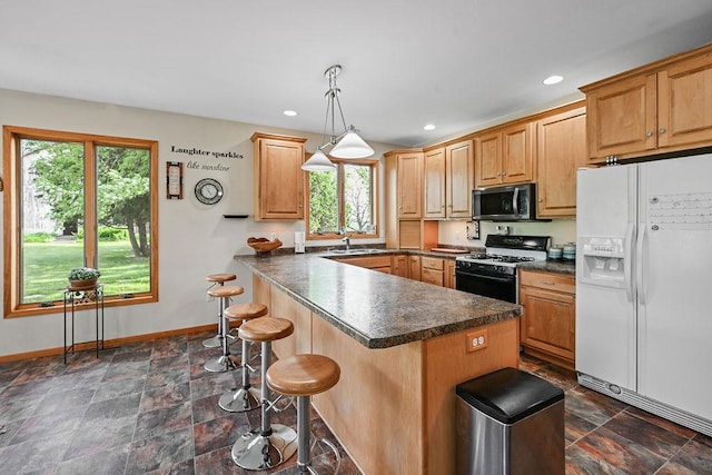 7129 S County Road Jj, Bancroft, WI 54921 - kitchen with white fridge with ice dispenser, gas stove, stainless steel microwave, healthy amount of natural light, and recessed lighting