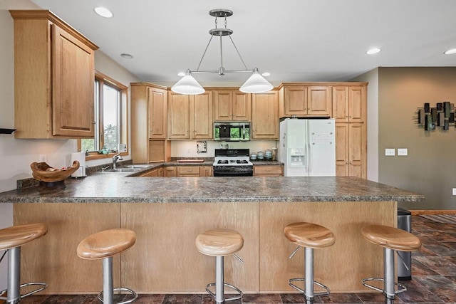 7129 S County Road Jj, Bancroft, WI 54921 - kitchen with white appliances, a sink, a peninsula, dark countertops, and a breakfast bar area