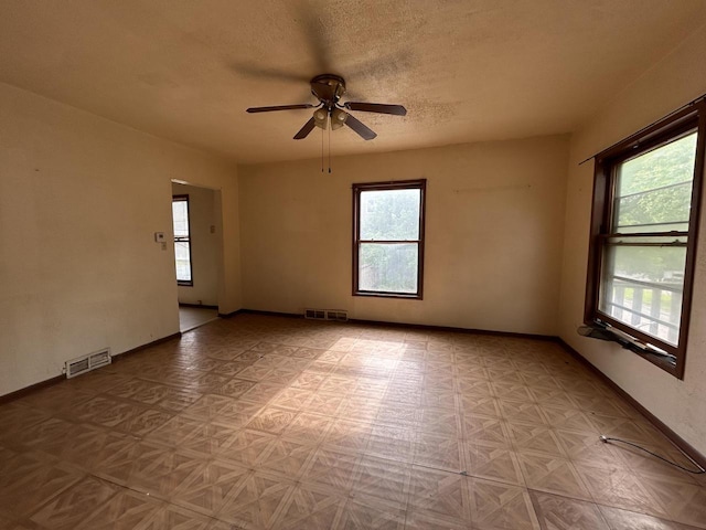 1218 W Locust St, Milwaukee, WI 53206 - unfurnished room with healthy amount of natural light, a ceiling fan, and a textured ceiling