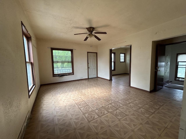 1218 W Locust St, Milwaukee, WI 53206 - empty room with healthy amount of natural light, ceiling fan, baseboards, and a textured ceiling