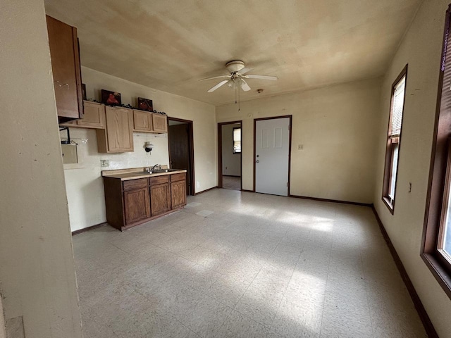 1218 W Locust St, Milwaukee, WI 53206 - kitchen featuring ceiling fan, baseboards, a sink, and light flooring