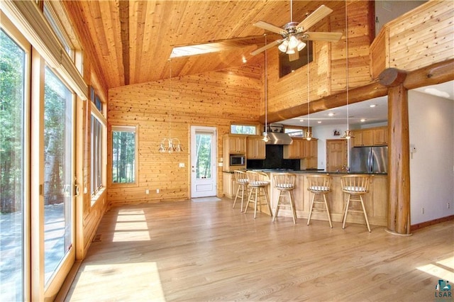 11053 N Robin Ln, Hayward, WI 54843 - kitchen with stainless steel appliances, a breakfast bar area, high vaulted ceiling, ventilation hood, and light wood-style flooring