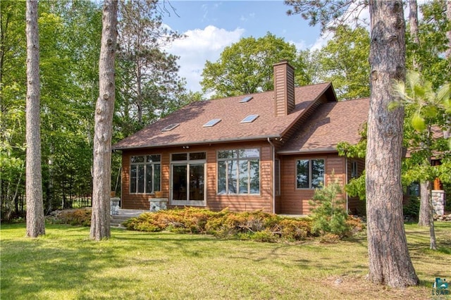 11053 N Robin Ln, Hayward, WI 54843 - back of house featuring a chimney, a yard, and roof with shingles