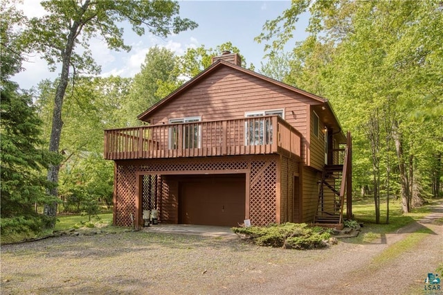 11053 N Robin Ln, Hayward, WI 54843 - view of front of home featuring driveway, a chimney, a garage, stairway, and a deck