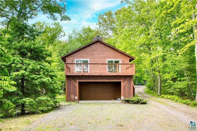 11053 N Robin Ln, Hayward, WI 54843 - view of property exterior featuring gravel driveway, a chimney, and a garage
