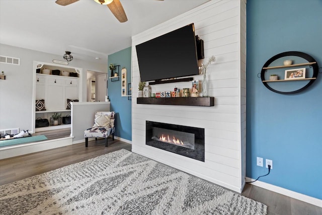3433 Illinois St, Mount Pleasant, WI 53405 - sitting room featuring wood finished floors, a ceiling fan, a large fireplace, and baseboards